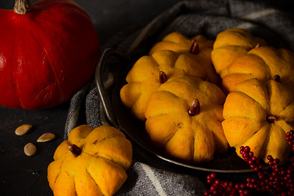 Kürbisbrötchen Rezept aus Hefeteig mit Kürbis, geformt wie kleine Kürbisse und herbstlich angerichtet.