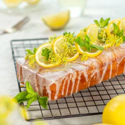 Der beste Zitronenkuchen – unwiderstehlich saftig & schnell gemacht Saftiger Zitronenkuchen mit hellem Zitronenguss und frischer Zitronennote auf einem Teller serviert.