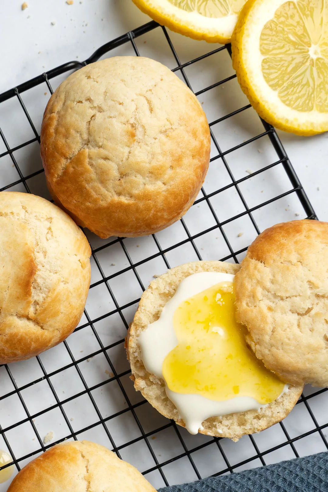 Frisch gebackene Scones mit Zitronencreme auf einem Kuchengitter.