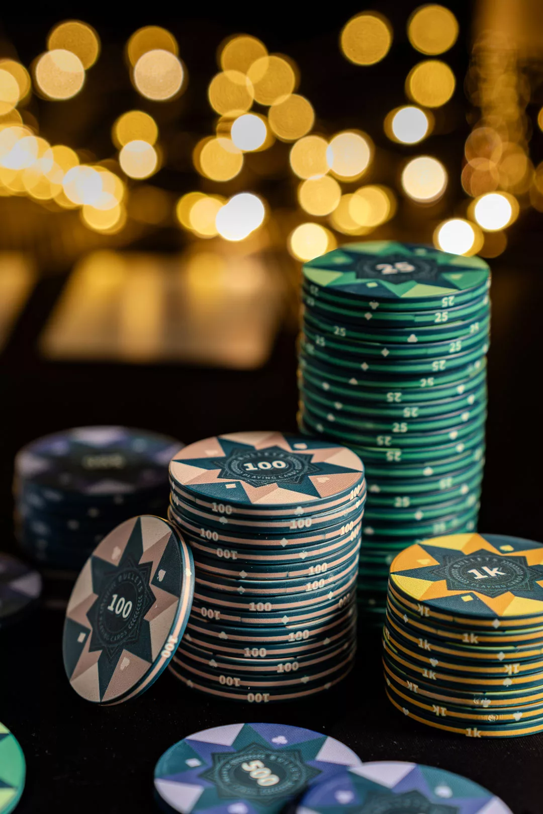 Pokerabend Essen: Schwarzer Pokertisch mit bunten Pokerchips und Spielkarten.