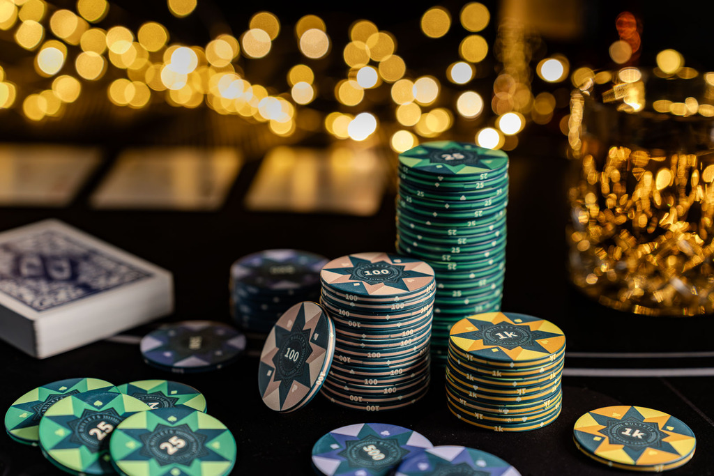 Detaillierte Nahaufnahme von Pokerchips und Spielkarten auf einem schwarzen Pokertisch.