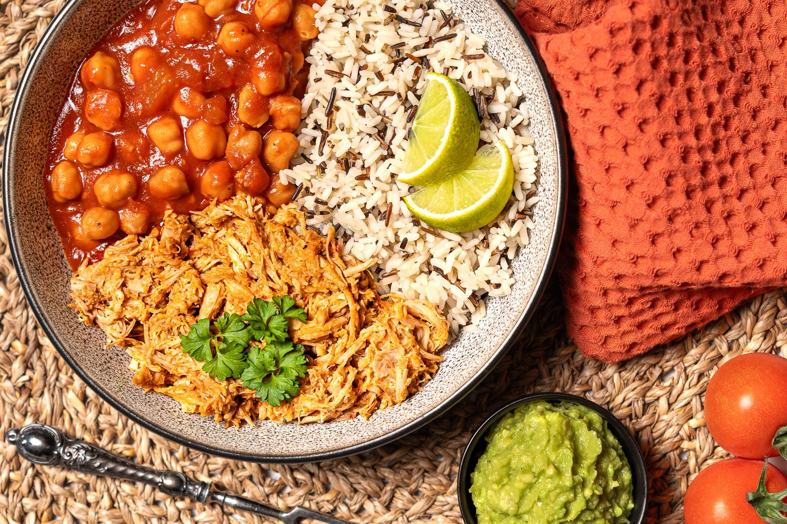 Proteinreiche Bowl mit Pulled Pork, Reis, würzigem Kichererbsen-Tomatensugo und Guacamole