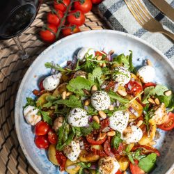 Gnocchi Salat mit Mini-Mozzarella, getrockneten Tomaten und Rucola (in 20 Minuten fertig) Mediterraner Gnocchi-Salat mit Mini-Mozzarella, getrockneten Tomaten und Rucola in einer Schüssel angerichtet.