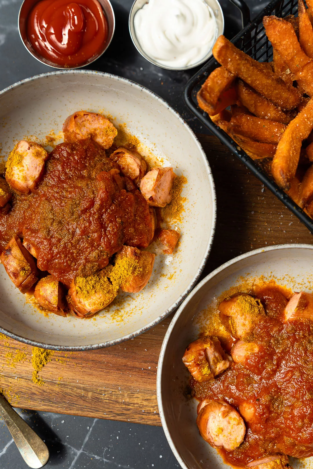 Currywurst selber machen mit würziger Currysoße, Currypulver und Pommes auf einem Teller, serviert als einfacher Imbiss-Klassiker.