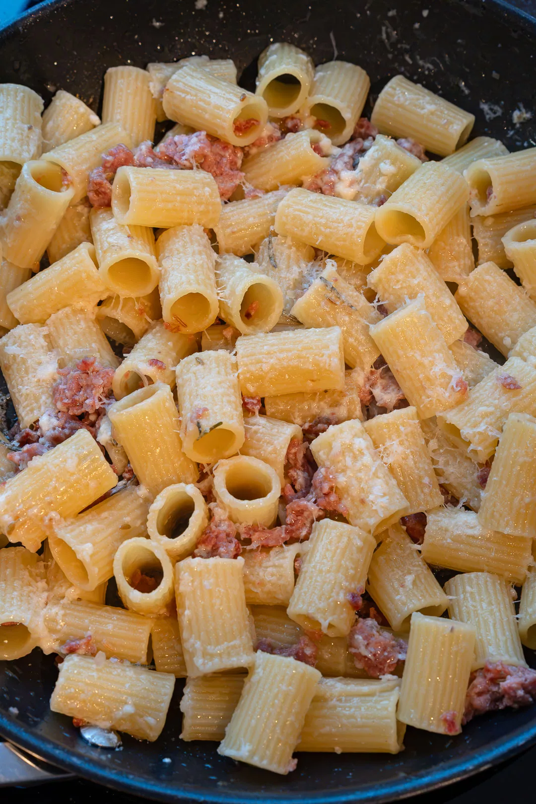 Zubereitete Pasta mit gebratener Salsiccia und frischen Feigen auf einem Teller serviert.